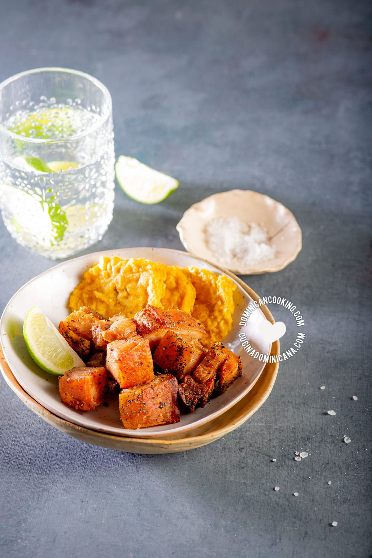 Air fryer chicharrones with tostones and lemon wedges.