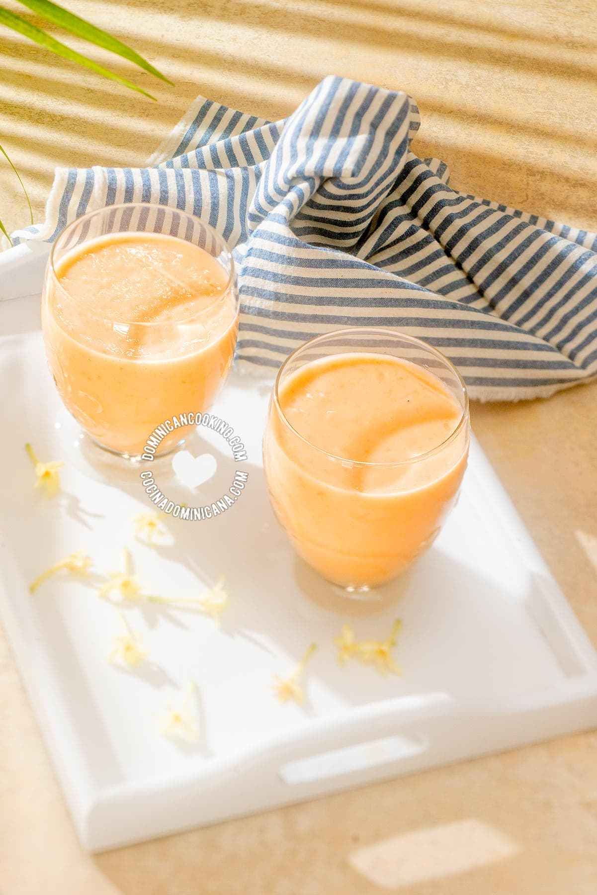 2 glasses of batida de lechosa (papaya milkshake) and papaya flowers.