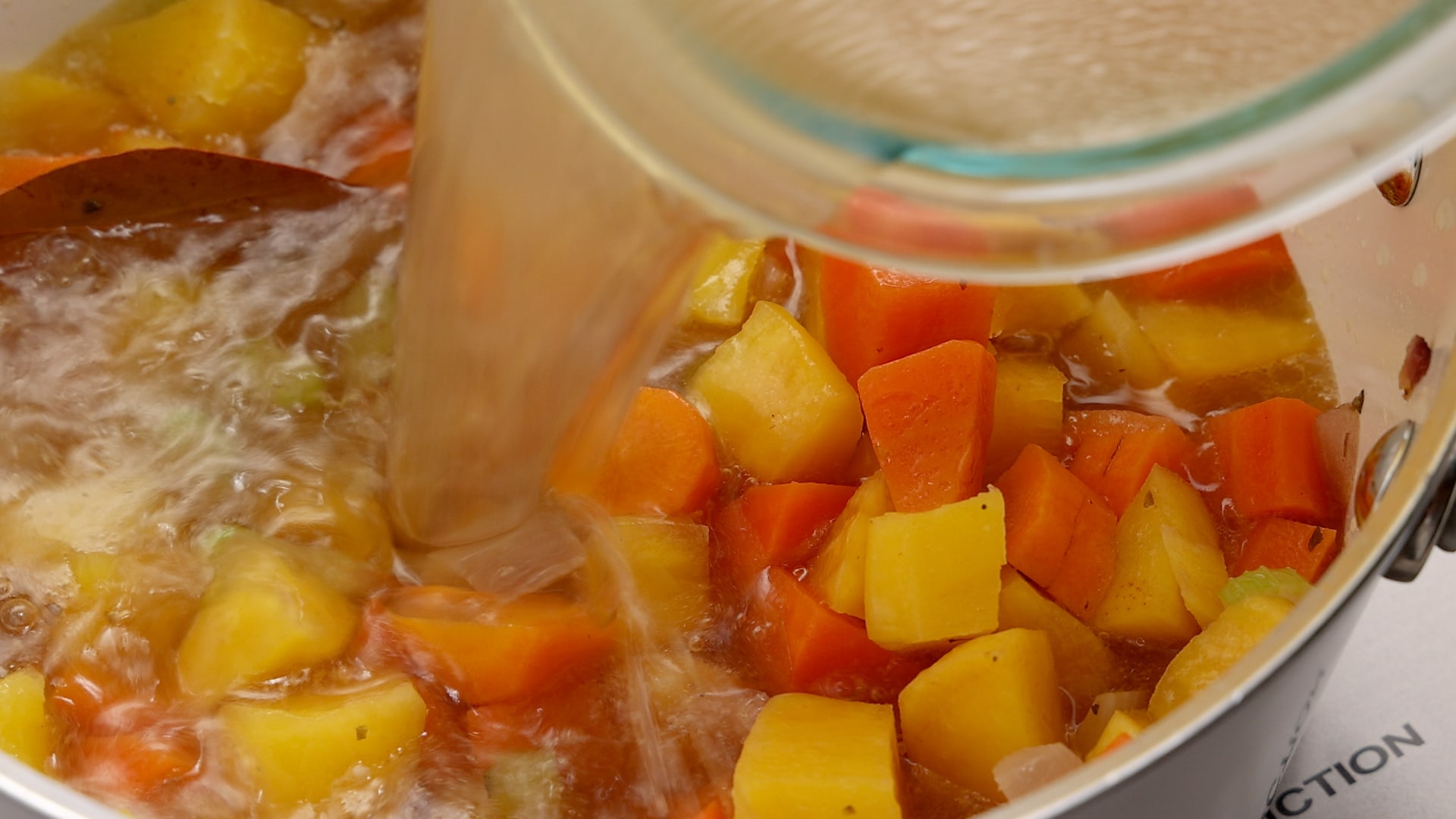 Adding broth to vegetables.