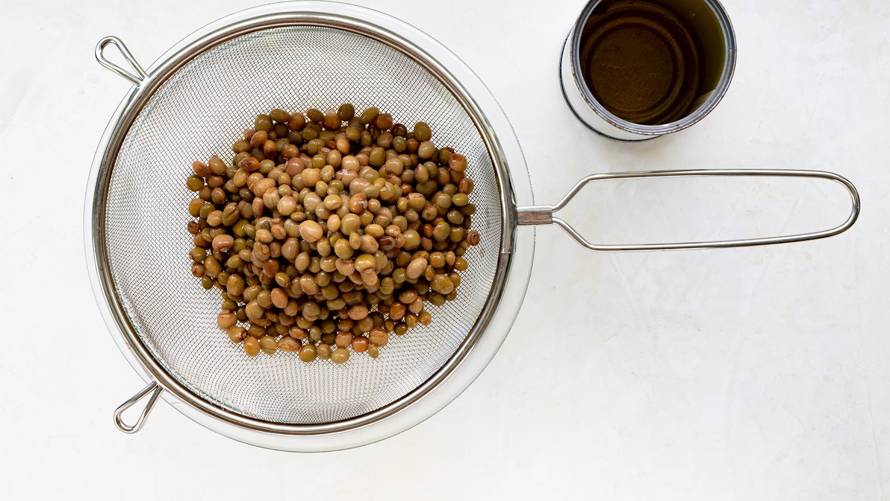 Draining canned guandules.
